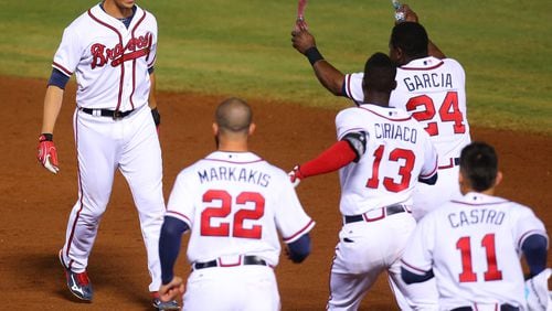 Braves teammates charge Andrelton Simmons after he hit a walk-off game-winning RBI single to beat Toronto 3-2 in September. Simmons was traded to the Los Angeles Angels Friday night. (Curtis Compton / ccompton@ajc.com)