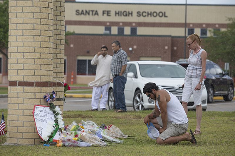 Alex Arriaga, who knew Glenda Ann Perkins, a substitute teacher who was killed, prays at a makeshift memorial for shooting victims outside Santa Fe High School in Santa Fe, Texas, May 20, 2018. A gunman killed 10 people and wounded 13 others at the high school on Friday.