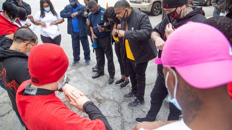 John Wilson, (center) pastor of the Gillem Community Church, prays with the volunteers before the start of the coat, blanket and gloves giveaway in Forest Park on Saturday, February 27, 2021. (Photo: Steve Schaefer for The Atlanta Journal-Constitution)