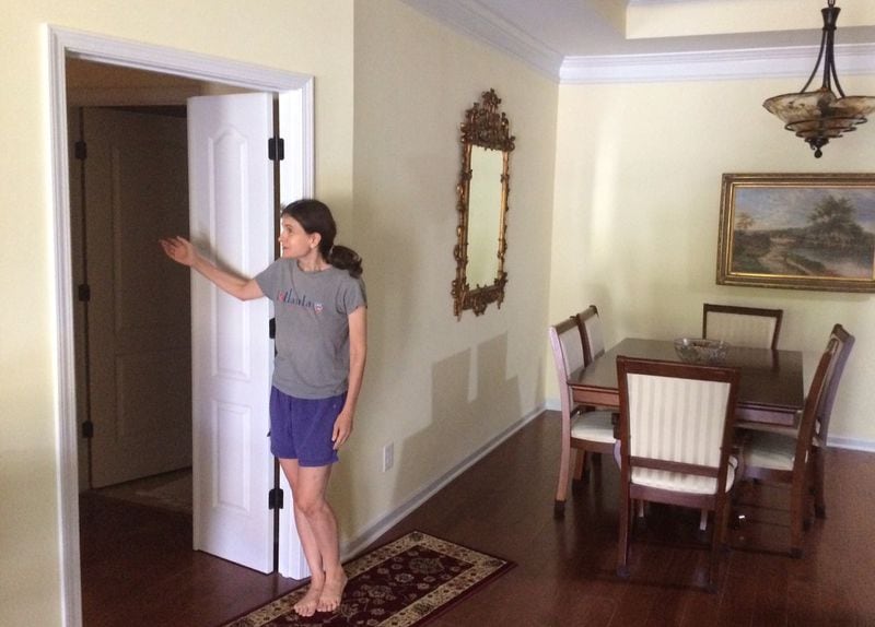 Susan Asher shows the door she installed in her townhome, work that caused the HOA to suspect that she was subdividing her residence. After an HOA in-home inspection, she was cleared. Photo by Bill Torpy