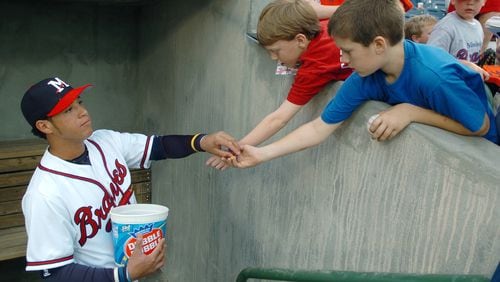 Gregor Blanco, left, of the Mississippi Braves shares some of the team's "professional-grade" bubble gum with youngsters before the team's home opener against the Montgomery Biscuits, Monday, April 18, 2005, at Trustmark Park in Pearl, Miss. The Double-A affiliate of the Atlanta Braves played their first game Monday, since relocating from Greenville, S.C. (AP Photo/Rogelio Solis)