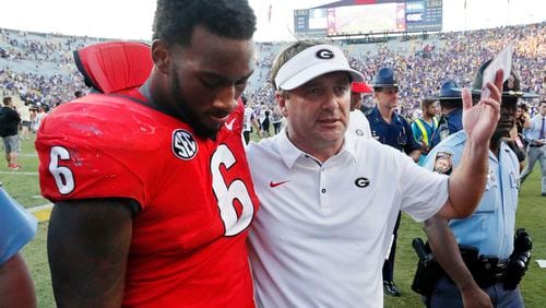 Georgia coach Kirby Smart walks off the field with  linebacker Natrez Patrick (6) after the loss.   BOB ANDRES / BANDRES@AJC.COM