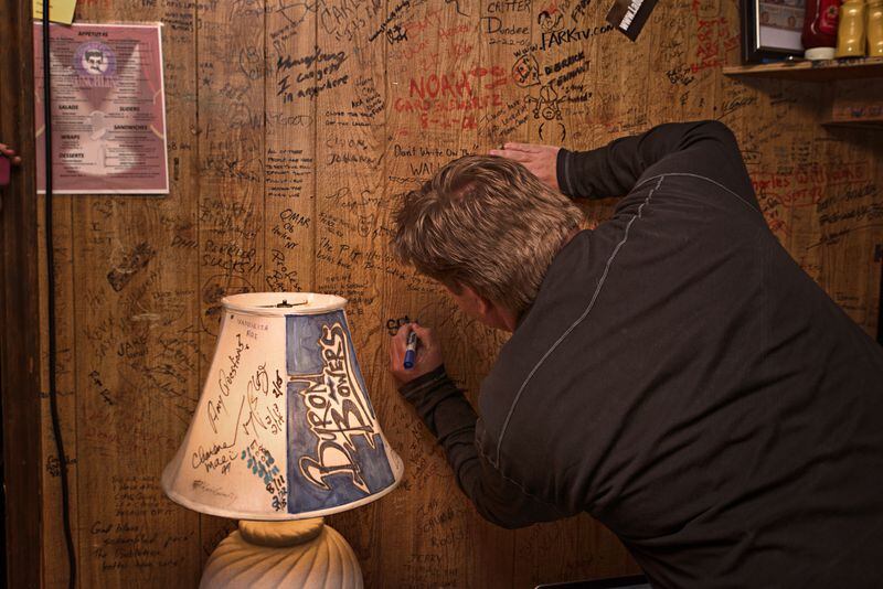 Jeff Dauler signing the green room wall at the Punchline just days before the locale shut down in late March, 2015. CREDIT: Gina McKenzie