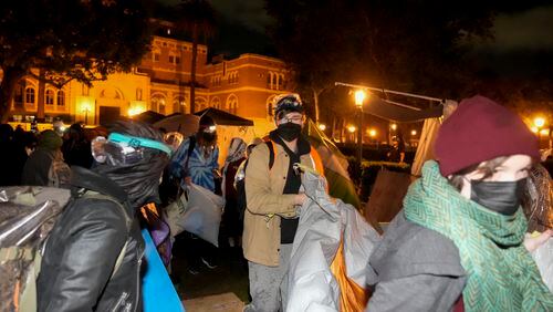 Pro-Palestinian demonstrators remove belongings from an encampment after police arrived on the campus at the University of Southern California Sunday, May 5, 2024, in Los Angeles. (AP Photo/Ryan Sun)