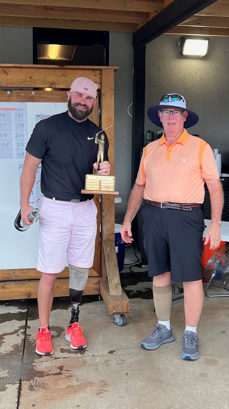 Shea Taylor (left) accepts the Georgia Amputee Championship trophy from tournament chairman Larry Rice.