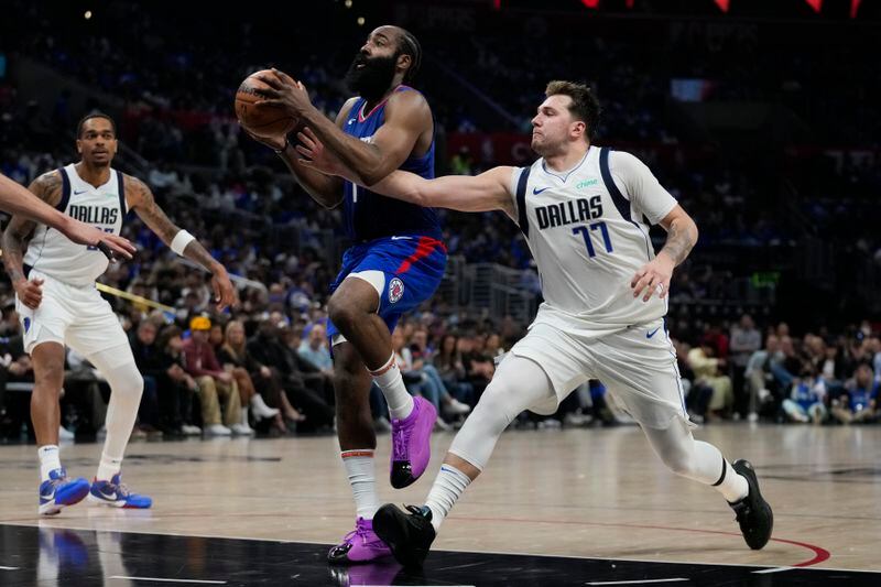 Dallas Mavericks guard Luka Doncic (77) defends against LA Clippers guard James Harden (1) during the first half of Game 1 of an NBA basketball first-round playoff series in Los Angeles, Sunday, April 21, 2024. (AP Photo/Ashley Landis)