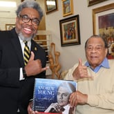 Author and Atlanta Journal-Constitution reporter Ernie Suggs and Ambassador Andrew Young flash the Alpha Phi Alpha Fraternity sign while holding a copy of the new book, "The Many Lives of Andrew Young." (Tyson A. Horne / tyson.horne@ajc.com)