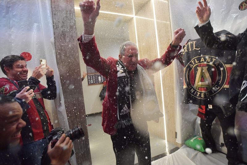 December 8, 2018 Atlanta - Atlanta United owner Arthur Blank gets soaked with beers as players celebrate in their locker room after Atlanta United beat the Portland Timbers during the MLS championship on Saturday, December 8, 2018. HYOSUB SHIN / HSHIN@AJC.COM