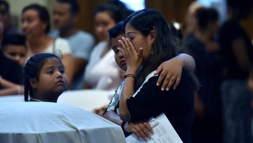 Lawrenceville - Family members mourn in front of the caskets of the victims â€” Martin Romero, 33, and four of his children â€” before the funeral mass for at St. Lawrence Catholic Church in Lawrenceville on July 13, 2017. Thirty-three-year-old Martin Romero and children Axel, 1, Dillan, 4, Dacota, 6 and Isabela Martinez, 10, were stabbed to death last week in their Loganville home. Nine-year-old daughter Diana Romero survived the attack. HYOSUB SHIN / HSHIN@AJC.COM