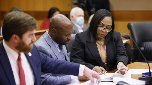 Fulton County D.A. Fani Willis (right) interacts with colleagues during a hearing where they suggest that Fulton County Superior Judge Robert McBurney not release the results of an eight-month-long investigation by a special grand jury to the public. Miguel Martinez / miguel.martinezjimenez@ajc.com