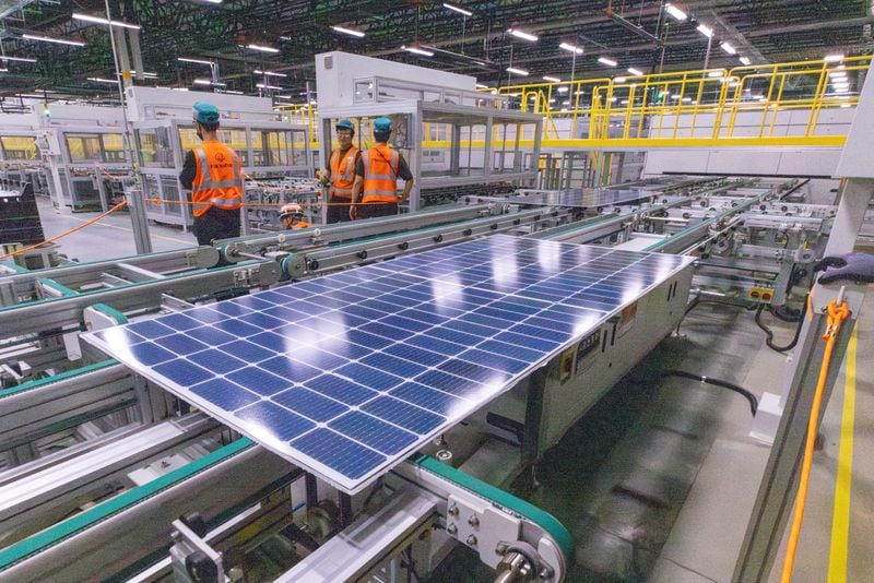 Workers keep an eye on the solar panels as they move through the automated assembly line at the Qcells module production facility in Cartersville on Tuesday, April 2, 2024.  (Steve Schaefer/steve.schaefer@ajc.com)
