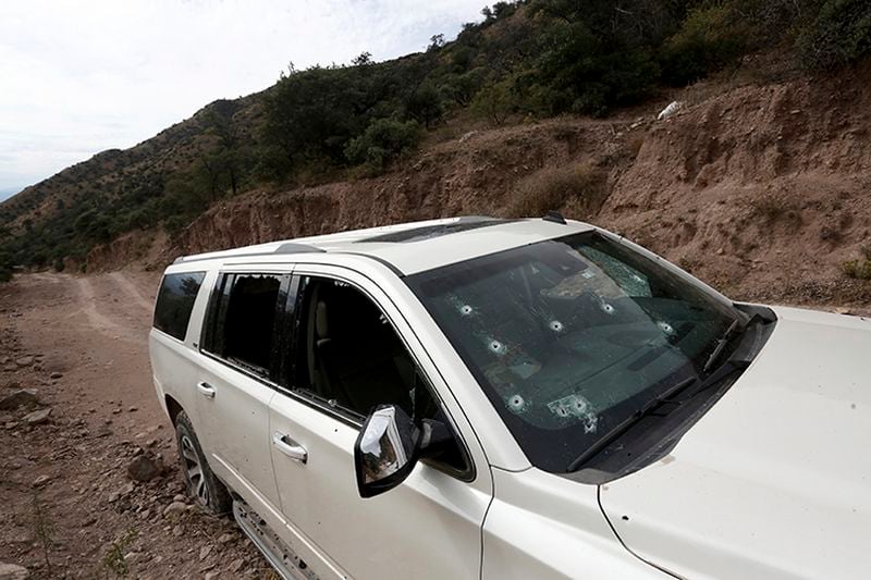 A bullet-riddled vehicle that members of the LeBaron family were traveling in sits parked on a dirt road near Bavispe, at the Sonora-Chihuahua border, Mexico, on Wednesday. Three women and six of their children, related to the extended LeBaron family, were gunned down in an attack while traveling along Mexico's Chihuahua and Sonora state border on Monday.