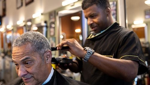 Barber Therelle Lewis gives Joe King, another barber, a trim at Off the Hook Barber Shop in Atlanta on Thursday, May 9, 2024. (Arvin Temkar / AJC)