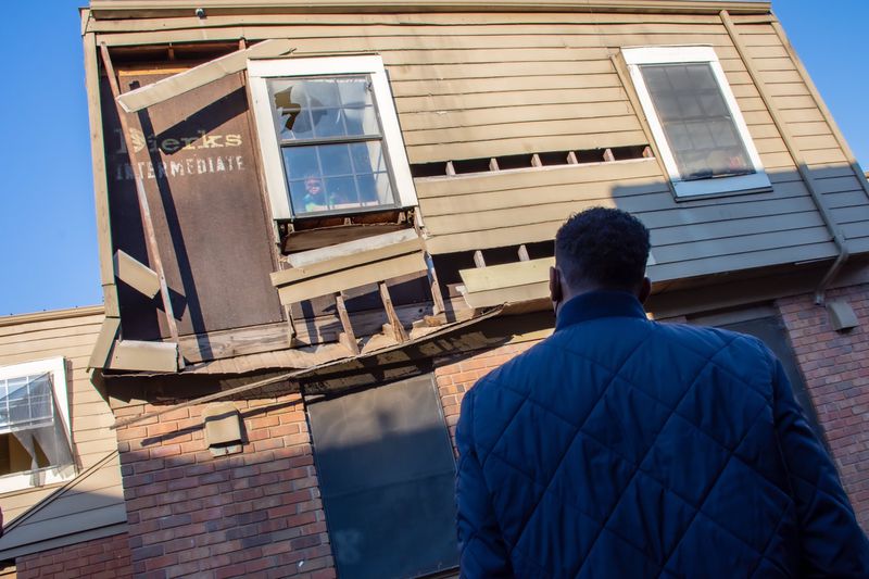 Atlanta Mayor Andre Dickens stares back at a child looking out of a near-collapsing window as he reviews the conditions at the Forest Cove Apartments in the Thomasville Heights community on Saturday, Feb. 12, 2022. (City of Atlanta)
