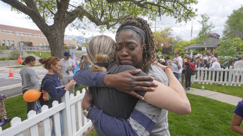 Bonneville Elementary School parents Hailey Anderson, left, and Mia Norman, right, hug during a block party supporting trans and non binary students and staff Monday, April 29, 2024, in Salt Lake City. Utah will become the latest state to implement a transgender ban for school bathrooms and locker rooms in public schools and government-owned buildings when the law passed by the Republican controlled Legislature takes effect.(AP Photo/Rick Bowmer)